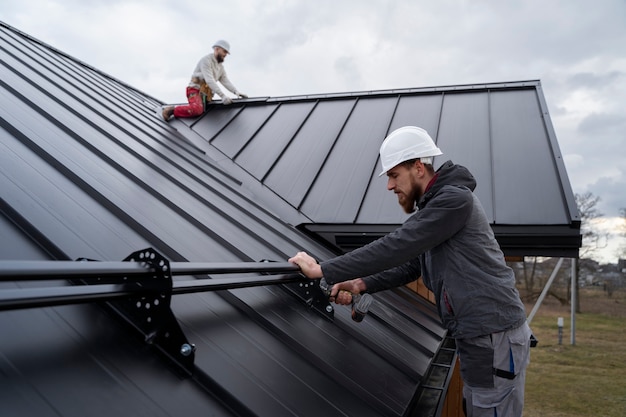 hommes travaillant sur un toit en metal